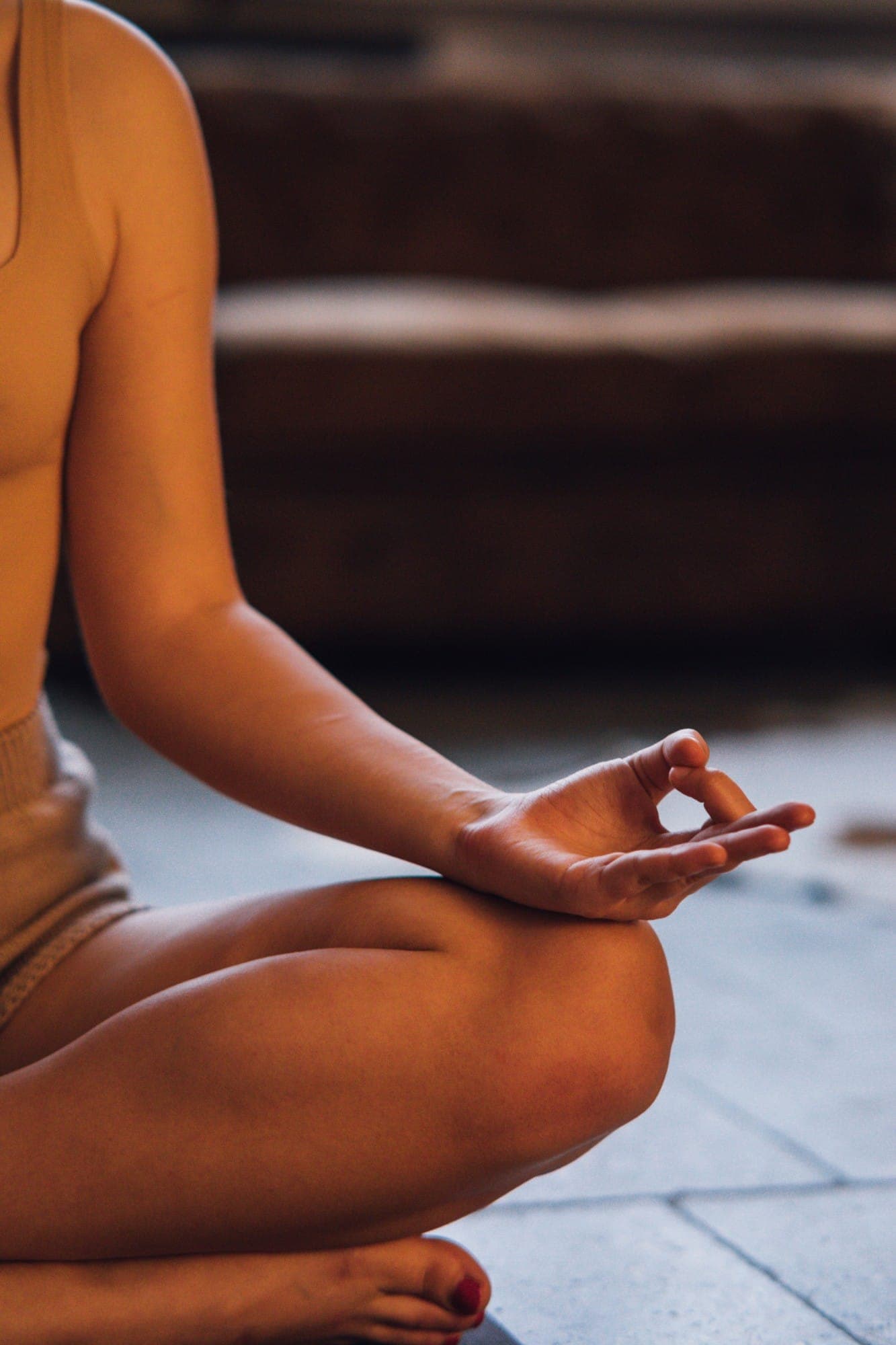 A hand resting on the knee in a mudra, thumb and forefinger touching, during seated practice