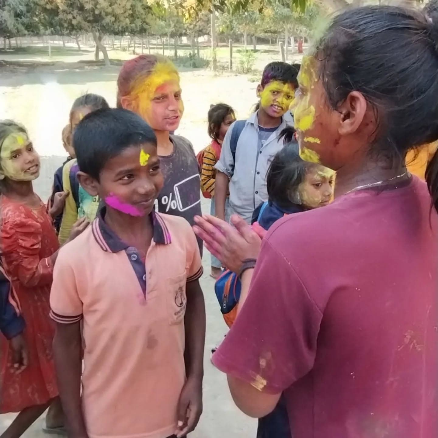 Children with coloured powder on their faces celebrating Holi