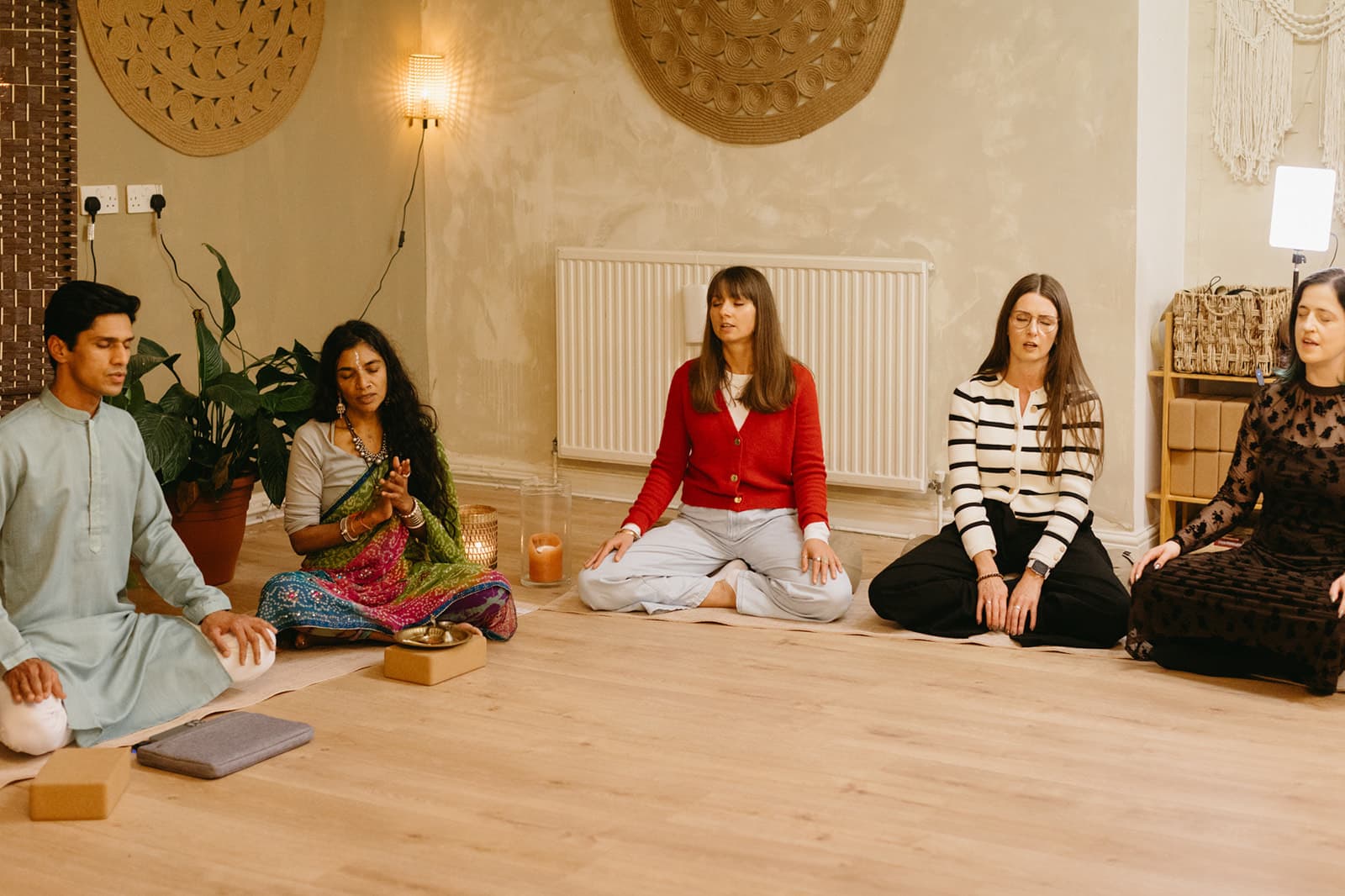 Yogi Madhav and a teacher lead trainees in seated meditation