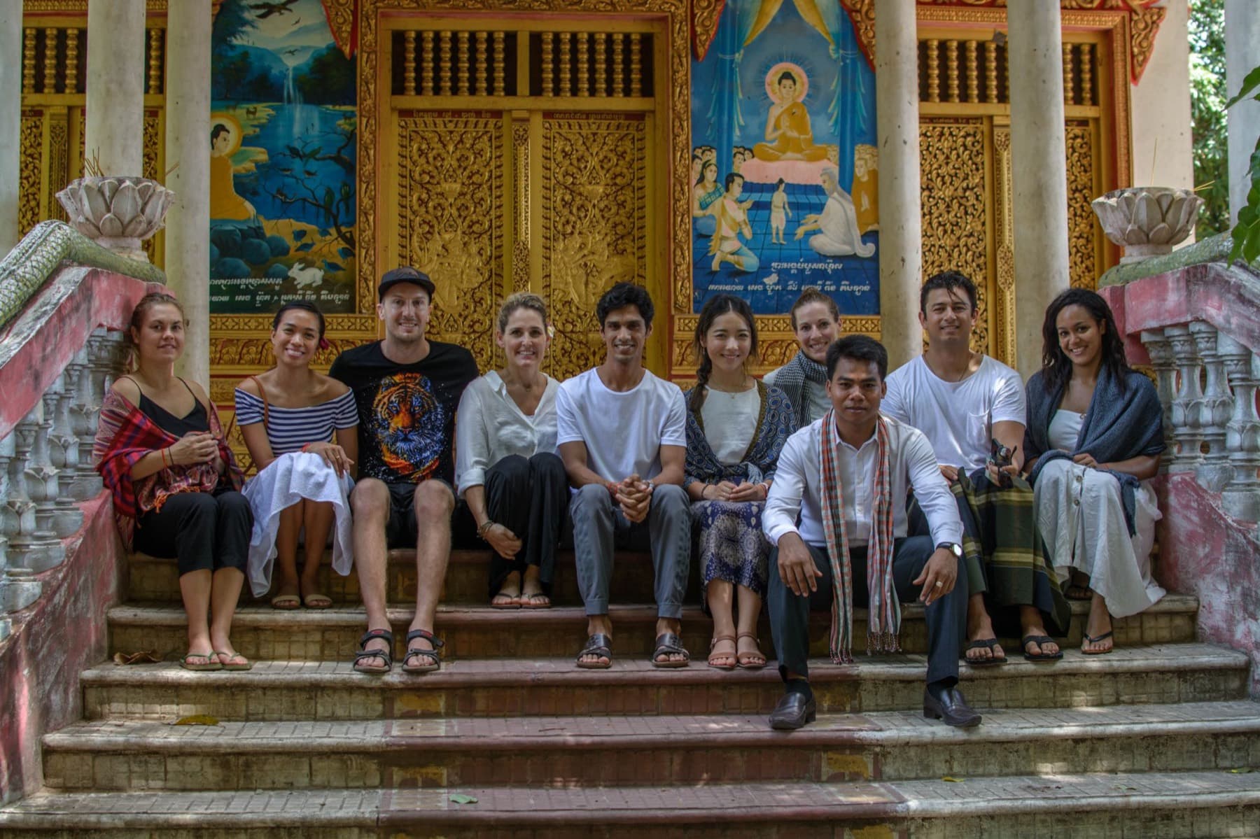 Yogi Madhav and students sitting on the steps of a temple in Cambodia