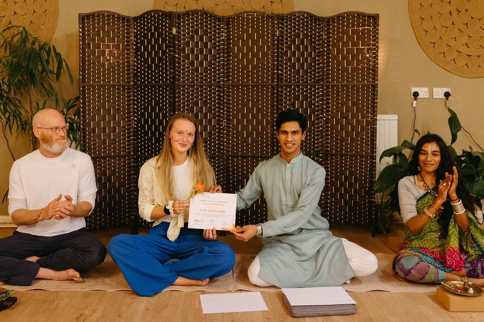 Yogi Madhav presenting a teacher training certificate to a graduate in North Wales
