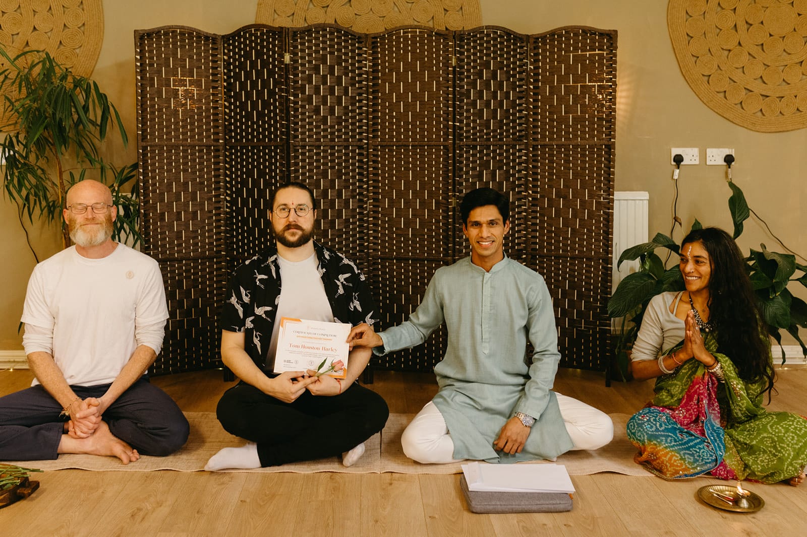 A graduate receives his teacher training certificate from Yogi Madhav