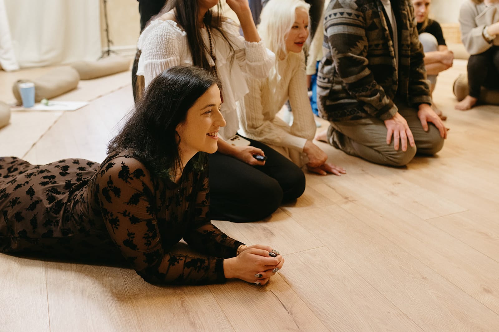 A trainee lying on the studio floor, smiling, among the group