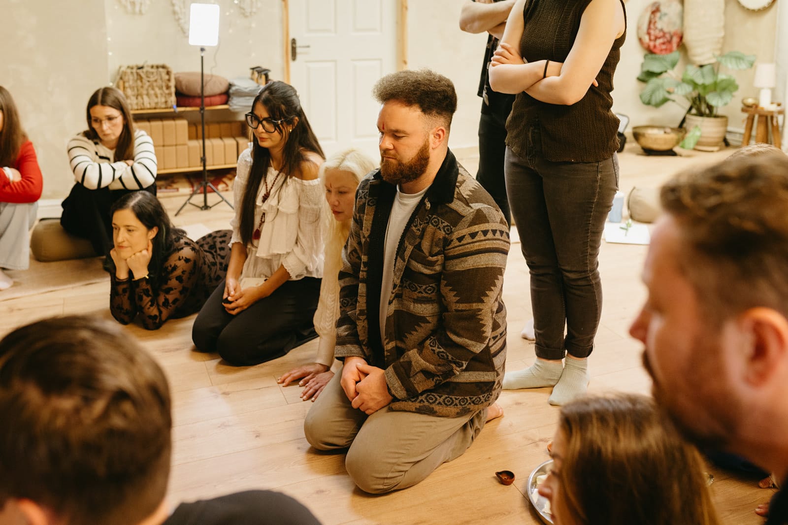 Trainees kneeling together on the studio floor during a workshop