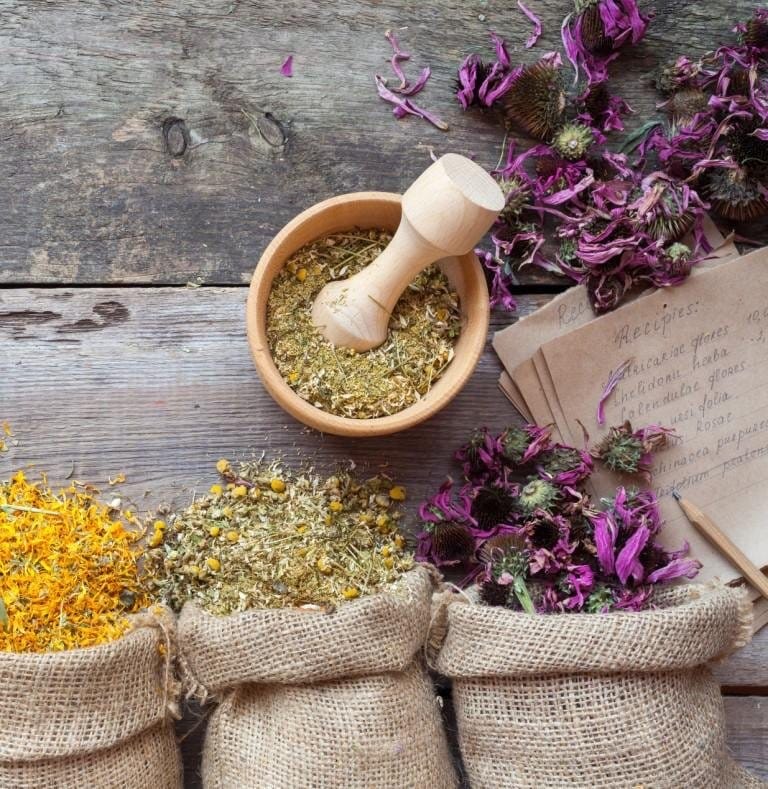 Dried Ayurvedic herbs and flowers with a wooden mortar and pestle
