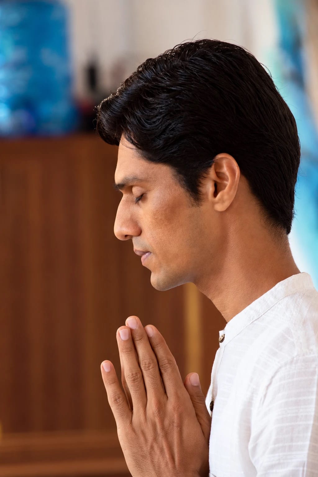 Yogi Madhav in profile, eyes closed, hands together in prayer